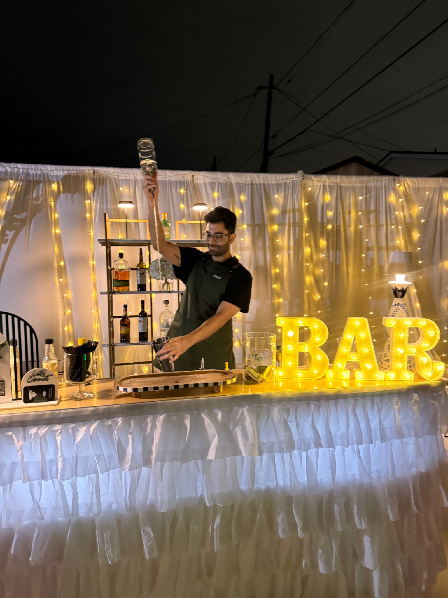 Edrik pouring a drink behind the Ambrosia bar